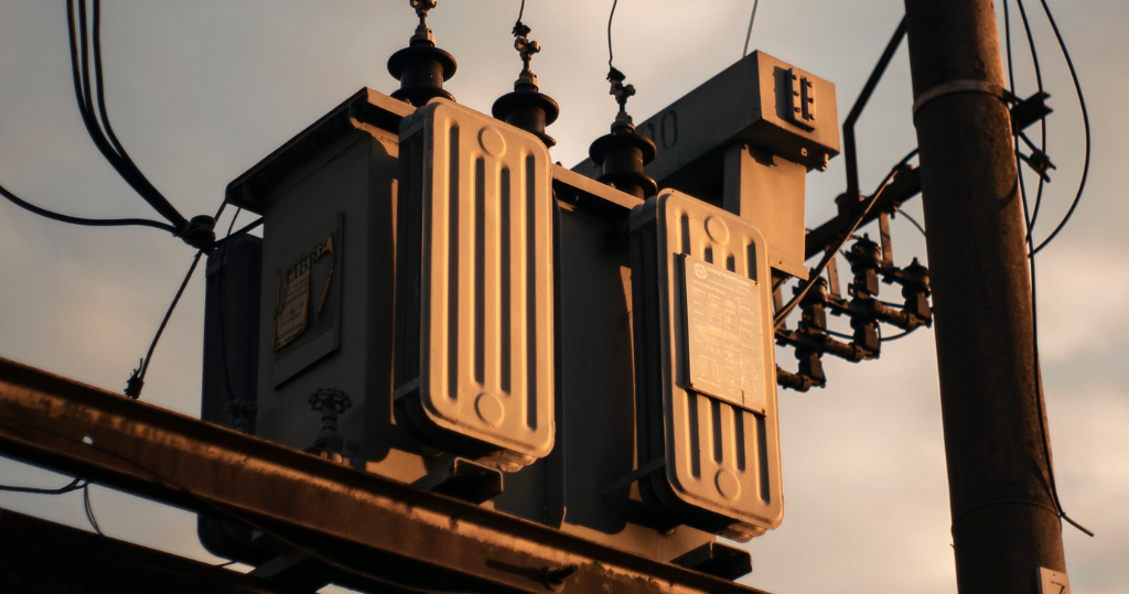 Pole-mounted distribution transformer and lines illustrating utility-side faults for power quality analyzer testing