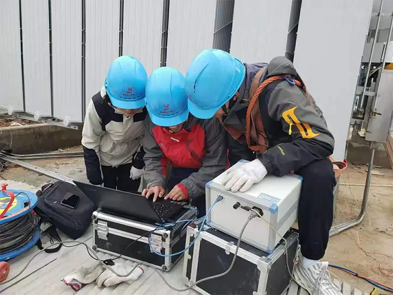 Engineers performing an on-site SFRA transformer test and analyzing data.